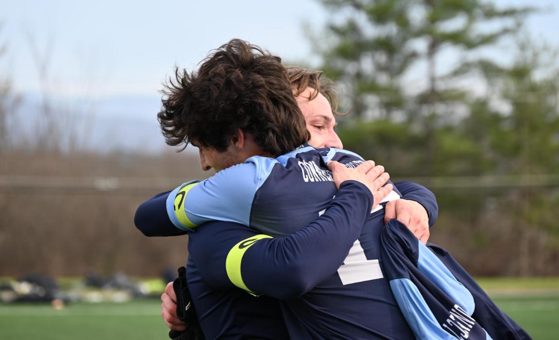 Men's soccer captains embracing after the match.