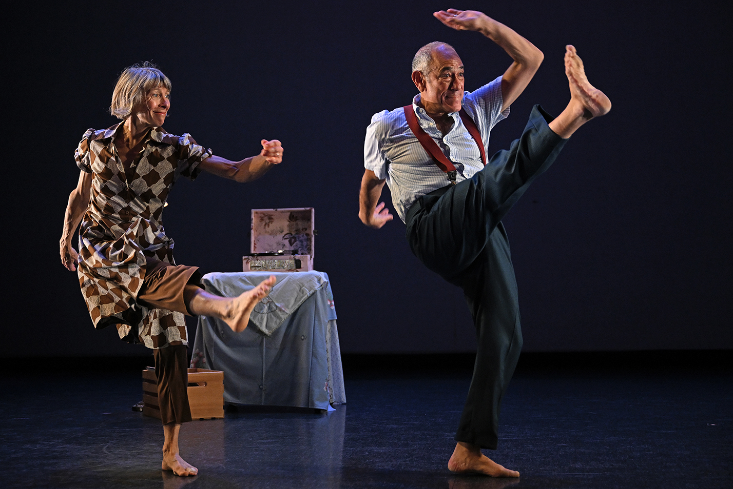 Two dancers perform high kicks on stage